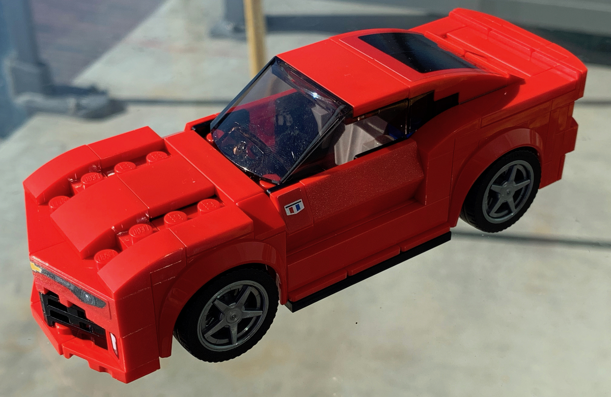 The 2016 Chevrolet Camaro LEGO Speed Champions model, in the original brochure colour of red. This angle really shows off the aggressive hood and sides of the car, using ramps and slopes to create a lot of texture in the body of the model.